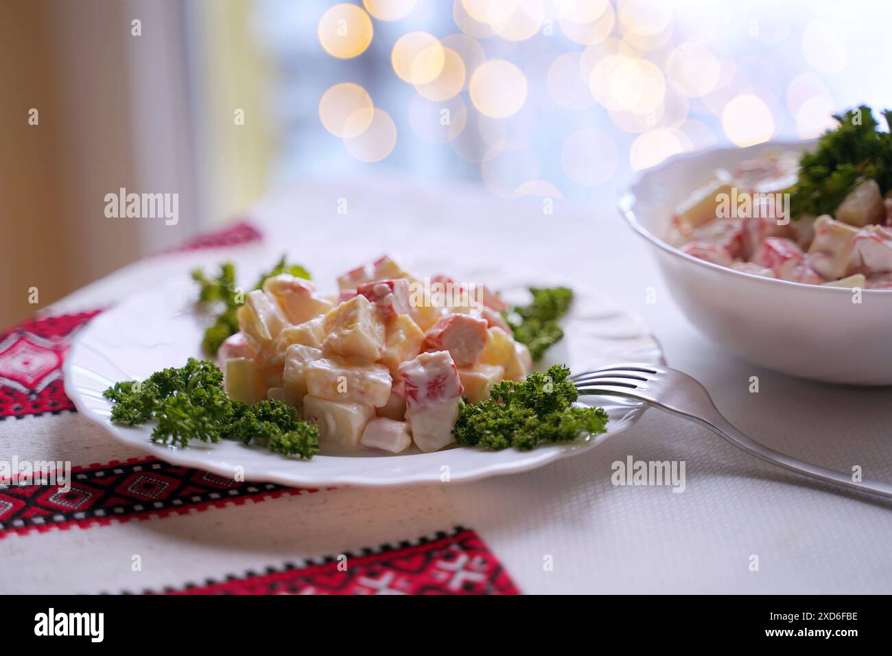 Insalata fatta in casa con bastoni di granchio tipica della moderna cucina Ucraina e di altre cucine dell'Europa orientale piatti tradizionali ucraini sul tavolo con Foto Stock