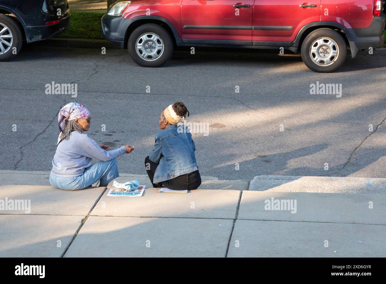 Detroit, Michigan - due donne siedono sul marciapiede fuori dalla galleria d'arte Shepherd durante la sua inaugurazione. Foto Stock