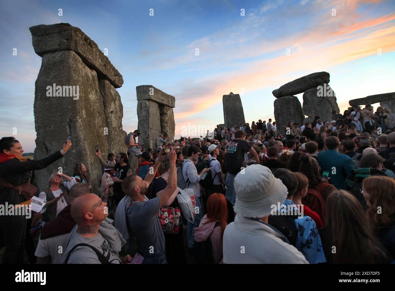 Salisbury, Inghilterra, Regno Unito. 20 giugno 2024. La gente si riunisce per celebrare il solstizio d'estate tra le pietre mentre il sole tramonta a Stonehenge. Stonehenge fu costruita dai primi britannici circa 4000 anni fa per allinearsi al sole sui solstizi. Il solstizio d'estate segna la fine della primavera e l'inizio dell'estate ed è il giorno più lungo e la notte più breve dell'emisfero settentrionale. L'evento è celebrato da migliaia di pagani in tutto il mondo con canti e balli. (Credit Image: © Martin Pope/ZUMA Press Wire) SOLO PER USO EDITORIALE! Non per USO commerciale! Foto Stock