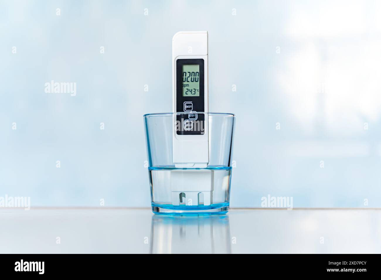 PHmetro elettronico in un bicchiere d'acqua. Misurazione TDS dell'acqua. scarsa qualità dell'acqua, valori elevati di impurità saline, Foto Stock