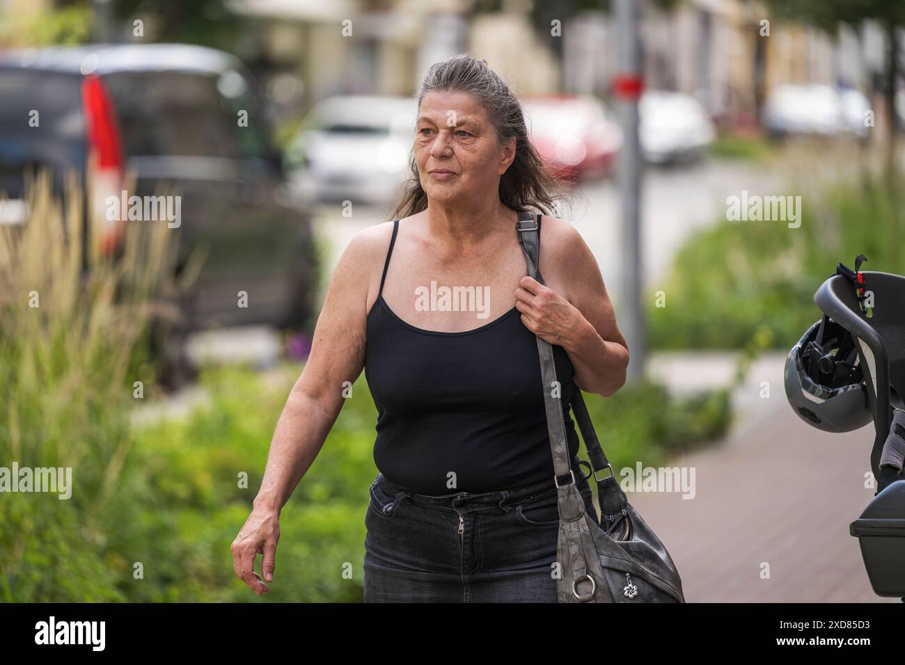 Una donna anziana che fa shopping in città Foto Stock