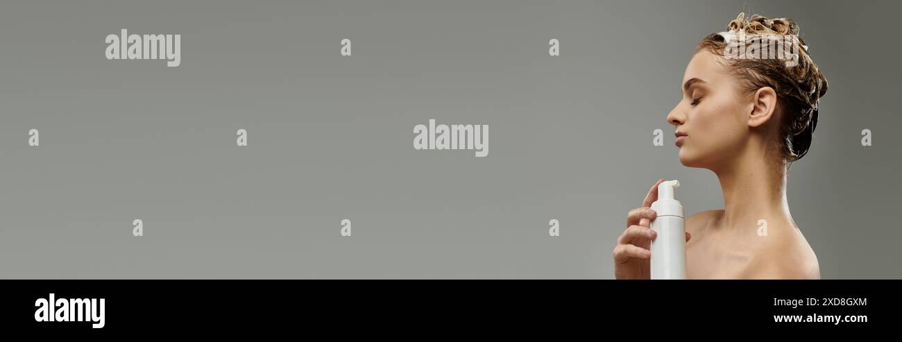 Donna elegante che applica un prodotto per la cura dei capelli e lava i capelli. Foto Stock