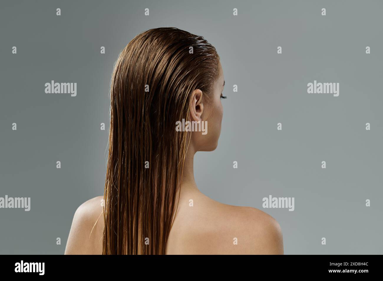 Una donna che rivela i suoi lunghi capelli bagnati. Foto Stock