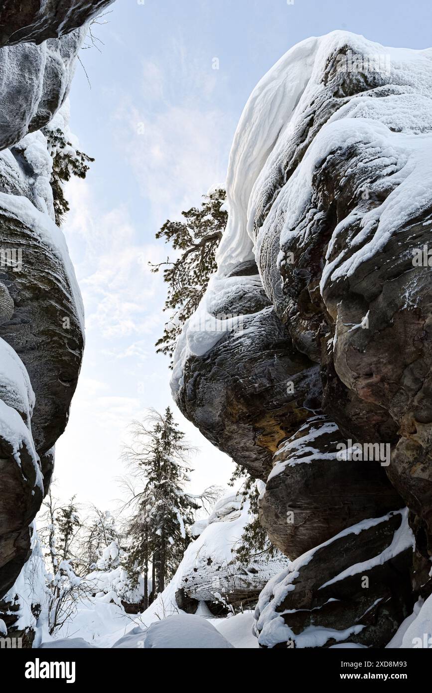 Formazioni rocciose innevate in una foresta invernale Foto Stock