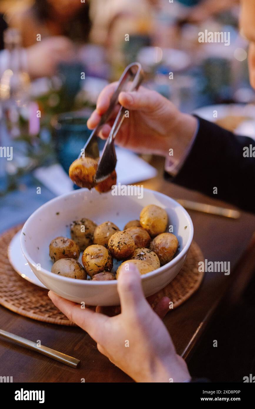 Le patate arrostite alle erbe vengono servite in una ciotola a una cena. Foto Stock