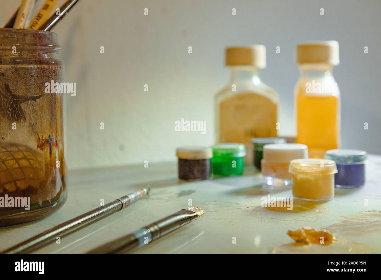 Forniture artistiche, tra cui pennelli, vasi di vernice e bottiglie Foto Stock