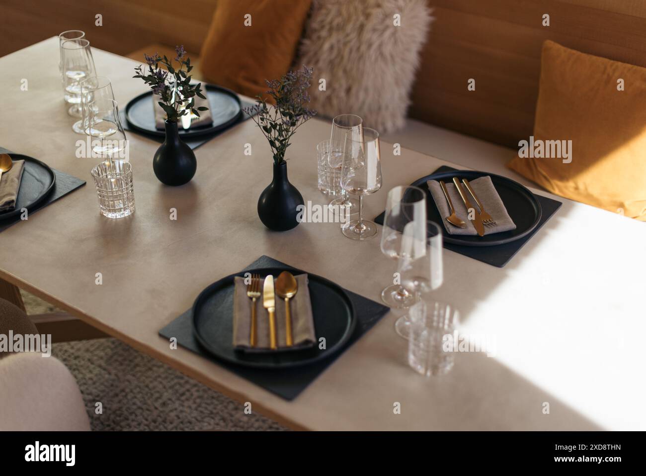 Elegante tavolo con vasi neri, bicchieri e posate dorate Foto Stock