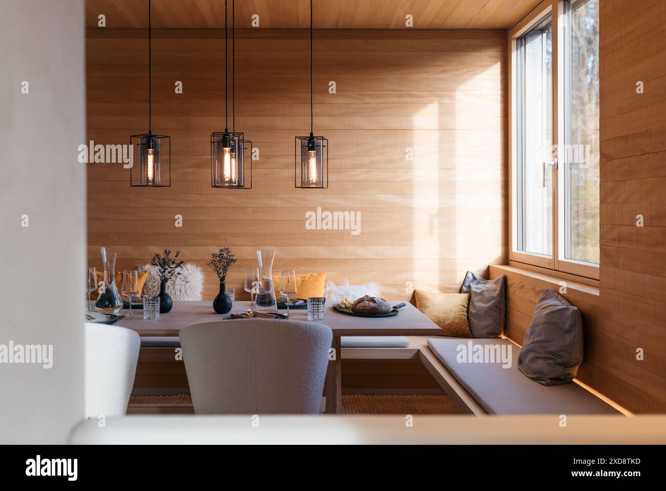 Moderna zona pranzo con elegante tavolo e intima decorazione in legno Foto Stock