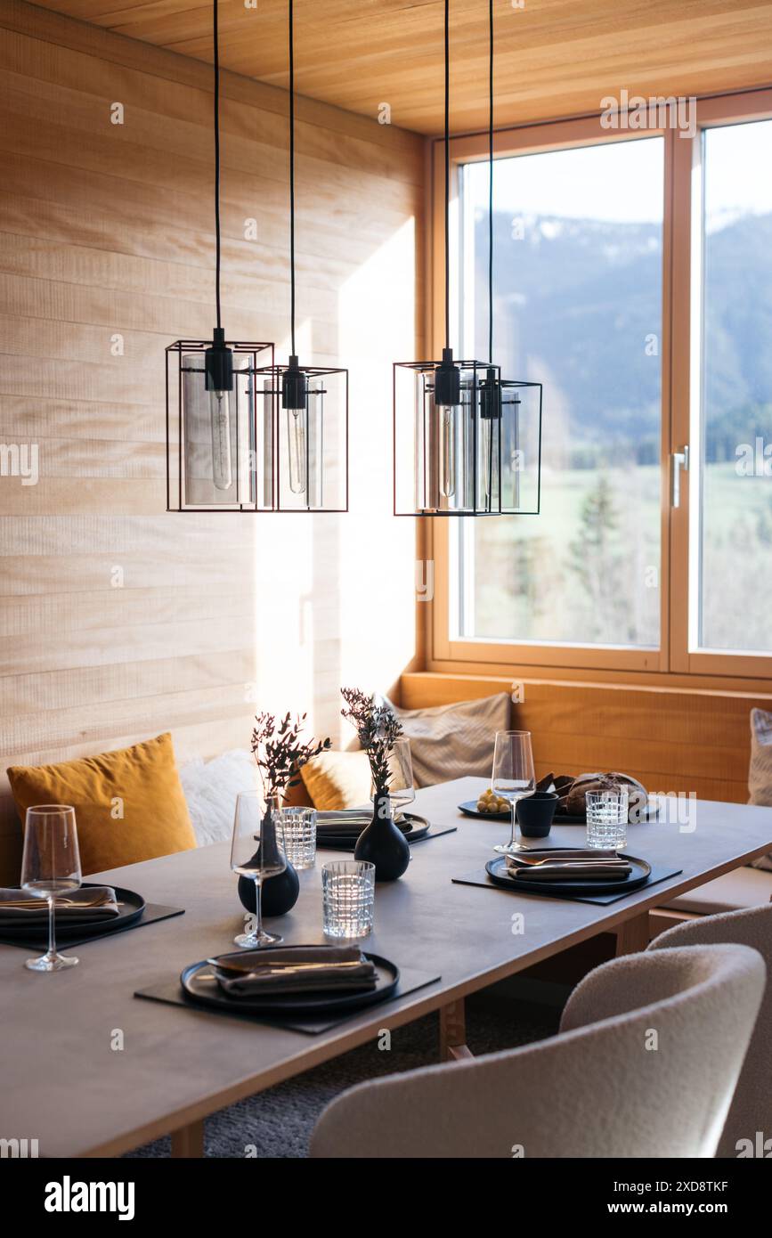 Moderno tavolo da pranzo con elegante arredamento e grandi finestre Foto Stock