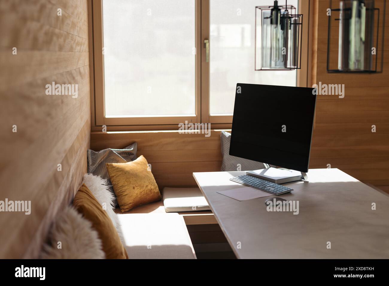 Moderno ufficio domestico con pareti in legno e un computer su una scrivania Foto Stock