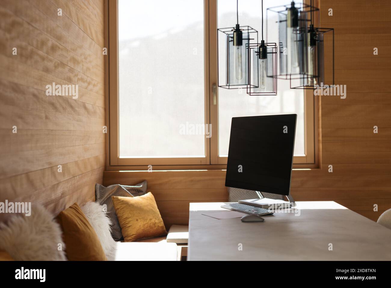 Moderno ufficio domestico con pareti in legno e un computer su una scrivania Foto Stock