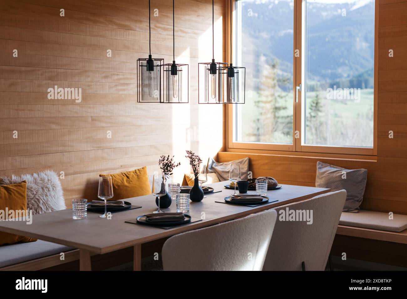 Moderno tavolo da pranzo con elegante arredamento e grandi finestre Foto Stock