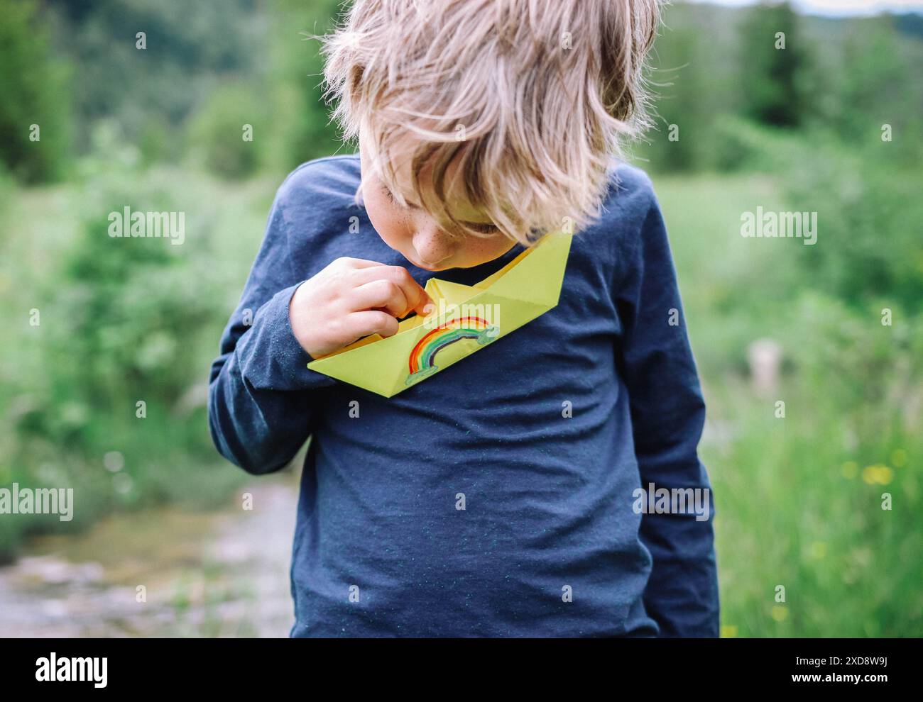 Un ragazzo e la sua barca arcobaleno Foto Stock