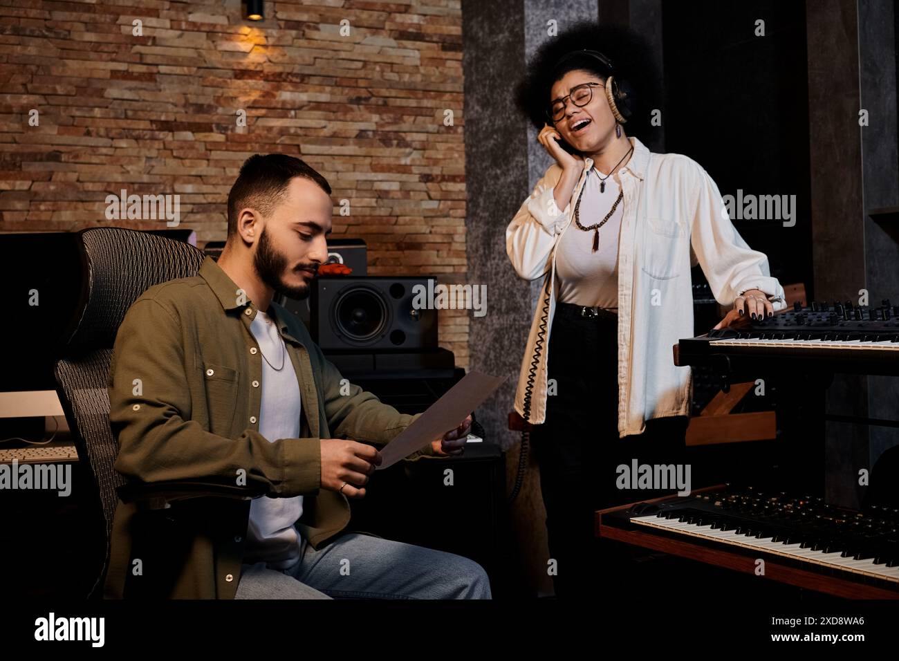 Un uomo e una donna in uno studio di registrazione, con note musicali e canti. Foto Stock