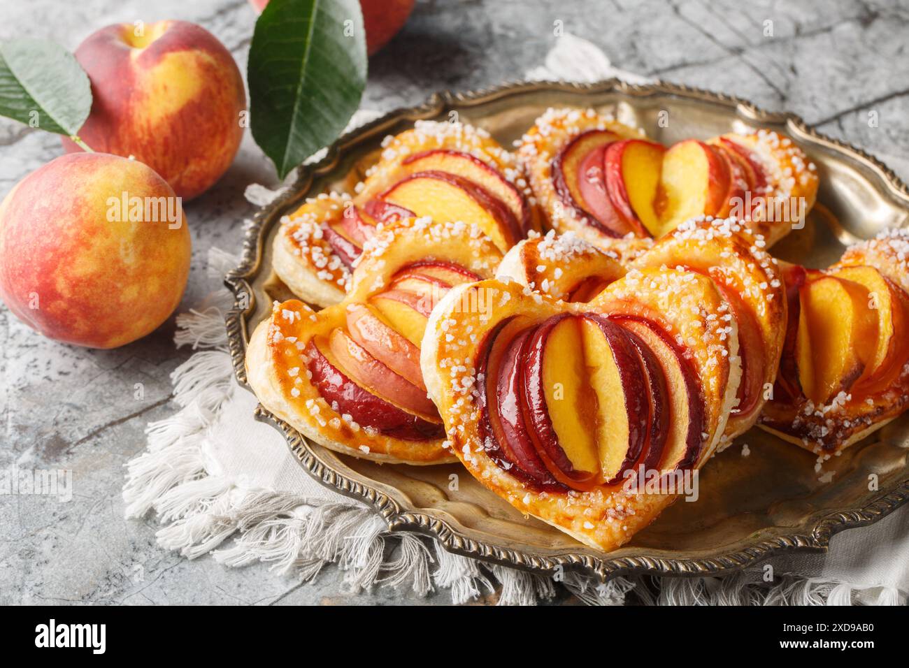 Deliziosa torta di cuore alla pesca con frutta fresca e marmellata da vicino in un piatto sul tavolo. Orizzontale Foto Stock