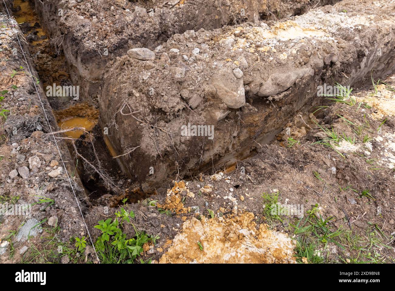 Lavori di costruzione in corso, angolo di fossati di fondamenta profonde in terreno sporco Foto Stock
