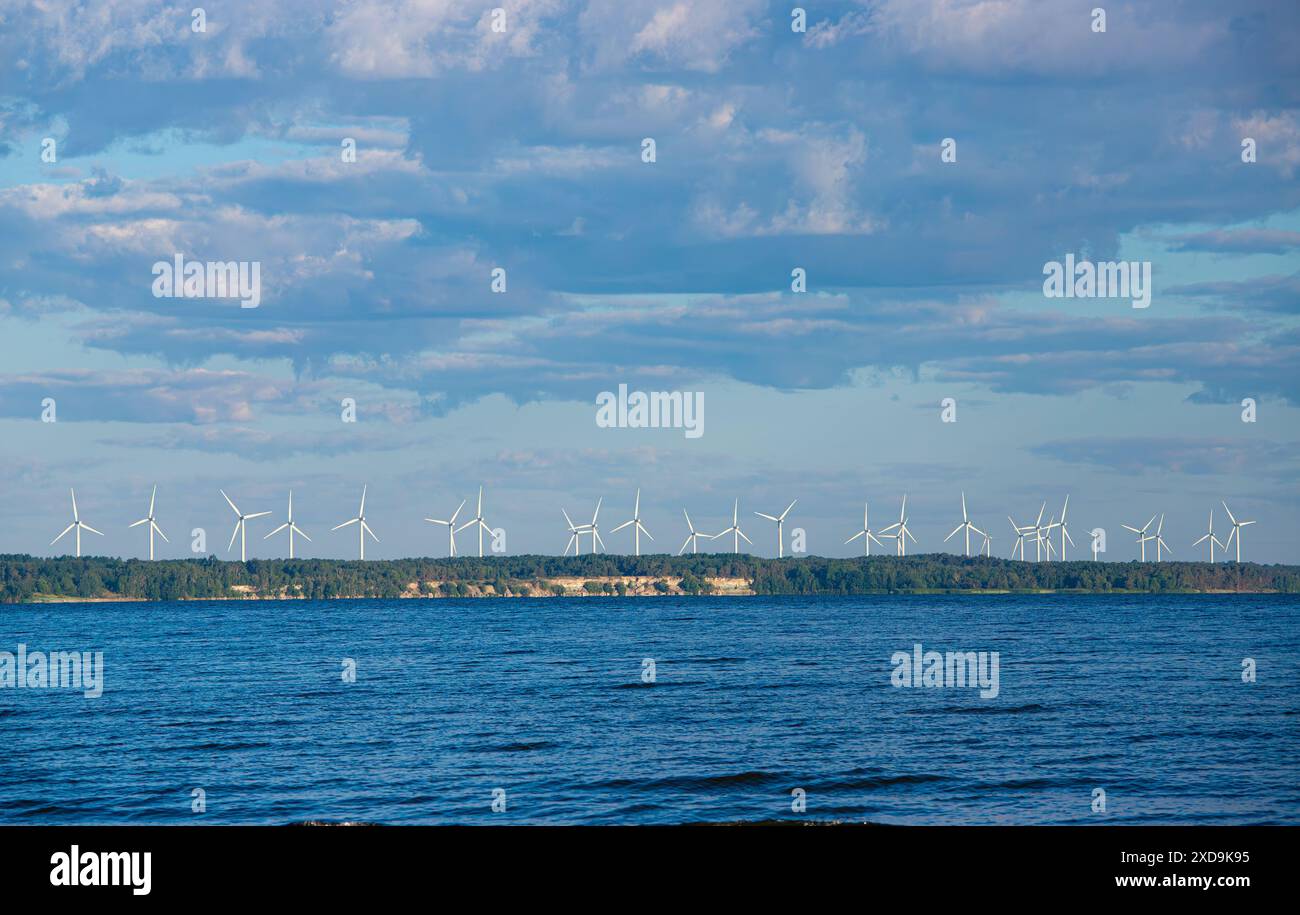 Centrale eolica onshore per la produzione di energia elettrica. Vista dall'alto. Cielo blu, mare blu, foresta verde, splendido scenario idilliaco. Molto spazio per le copie. Foto Stock