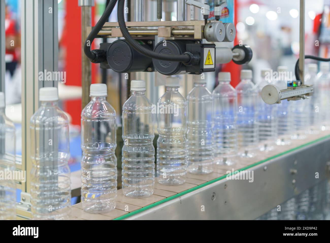 sistema di imbottigliamento automatizzato ad alta precisione al lavoro per riempire e tappare in modo efficiente i flaconi in un processo semplificato Foto Stock