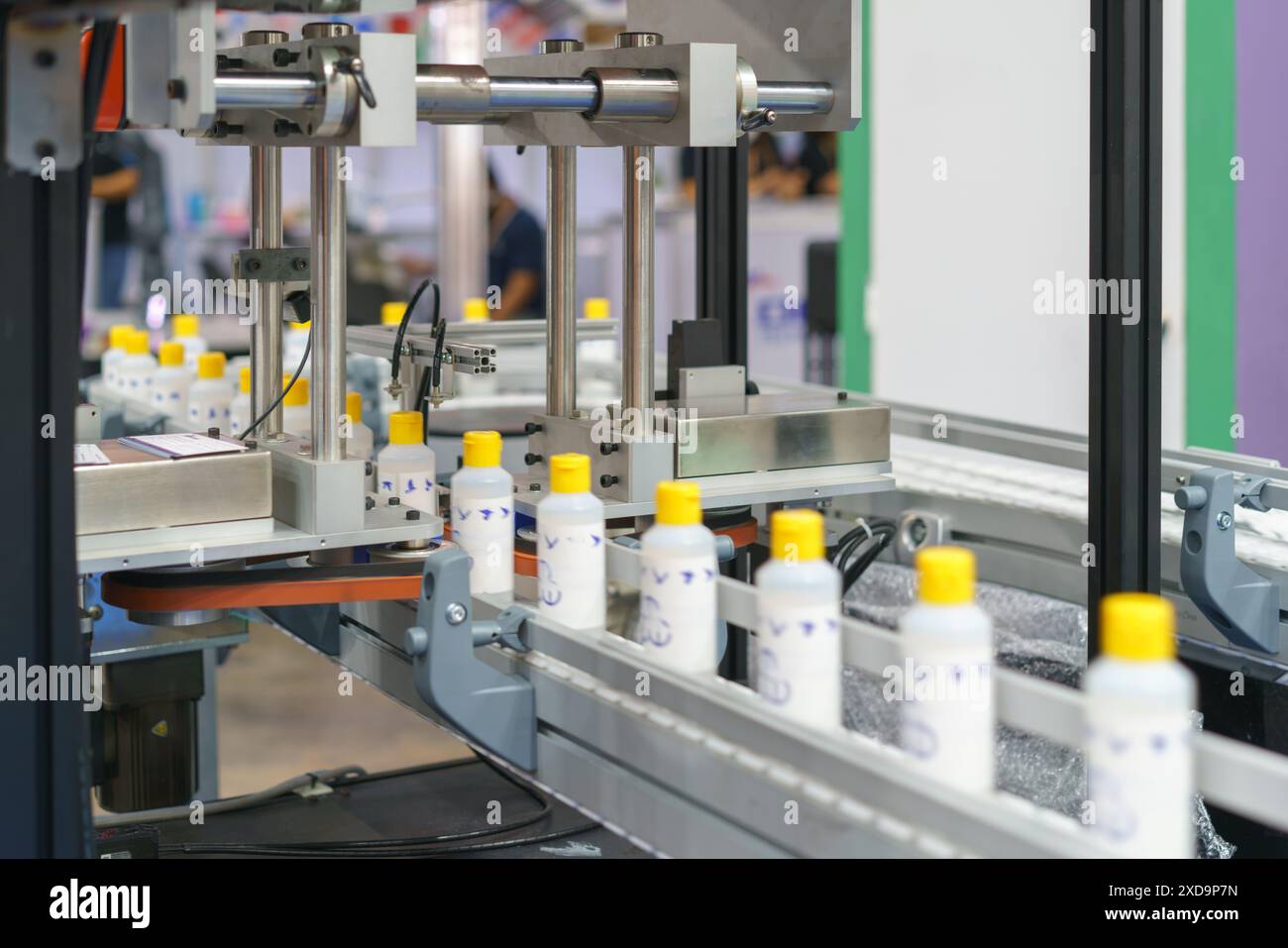 sistema di imbottigliamento automatizzato ad alta precisione al lavoro per riempire e tappare in modo efficiente i flaconi in un processo semplificato Foto Stock