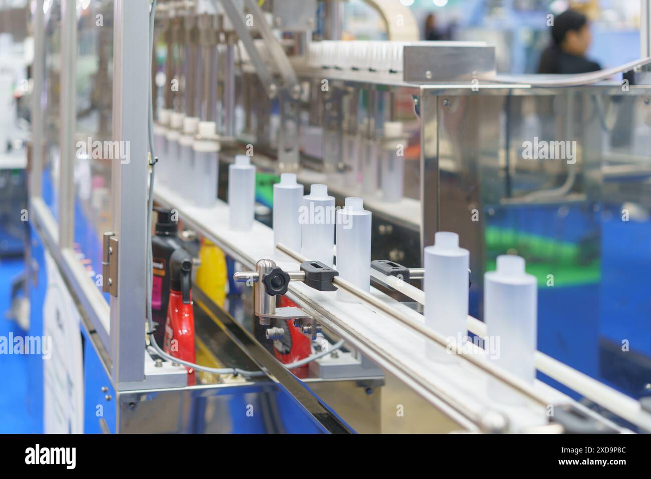 sistema di imbottigliamento automatizzato ad alta precisione al lavoro per riempire e tappare in modo efficiente i flaconi in un processo semplificato Foto Stock
