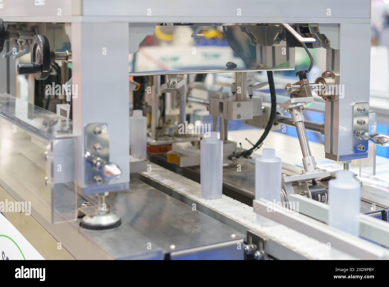 sistema di imbottigliamento automatizzato ad alta precisione al lavoro per riempire e tappare in modo efficiente i flaconi in un processo semplificato Foto Stock