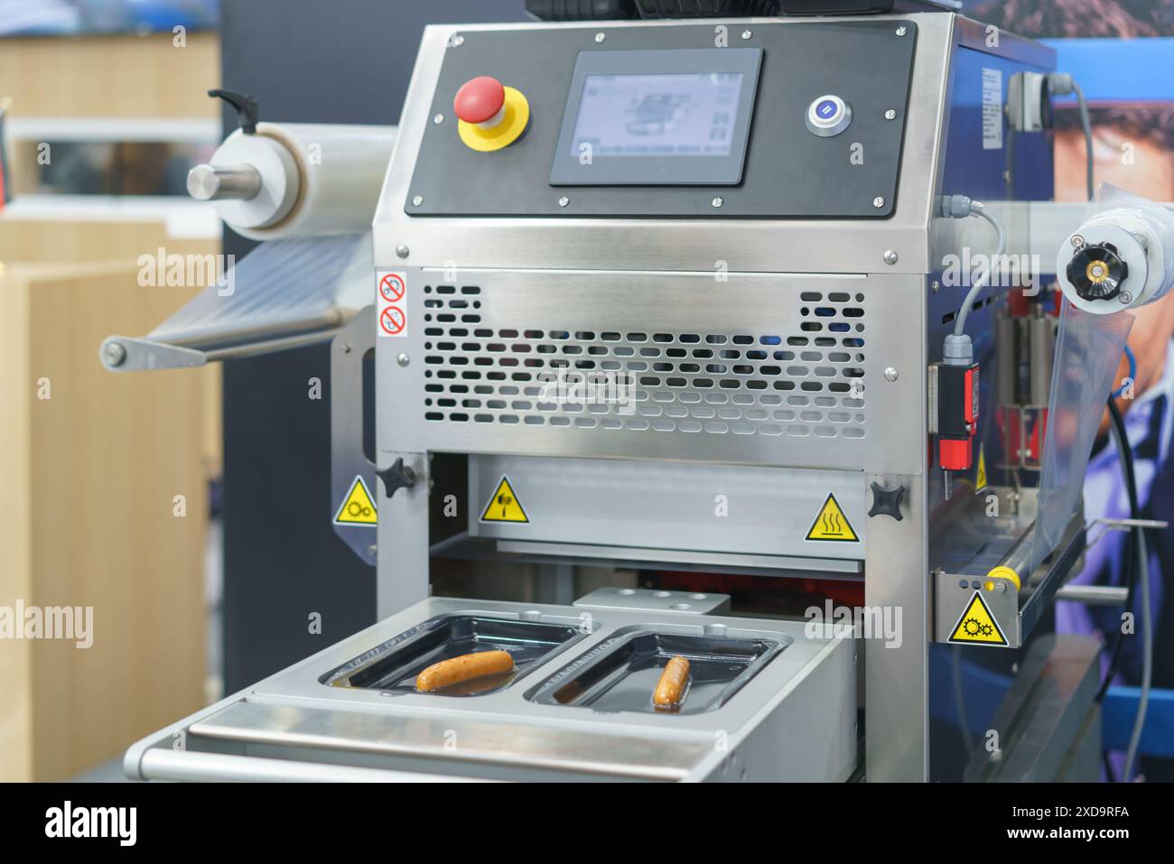 Macchina automatizzata per il confezionamento degli alimenti, progettata specificamente per sigillare e confezionare in modo efficiente prodotti alimentari come le salsicce Foto Stock