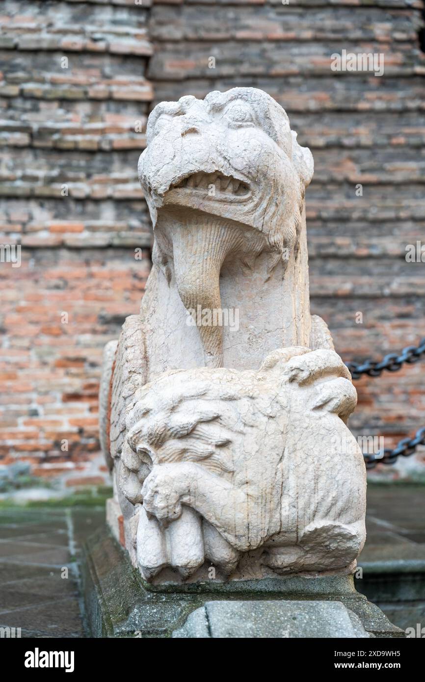 Primo piano su una scultura vintage in pietra che ritrae un mostro mitologico con un becco morso da un leone Foto Stock