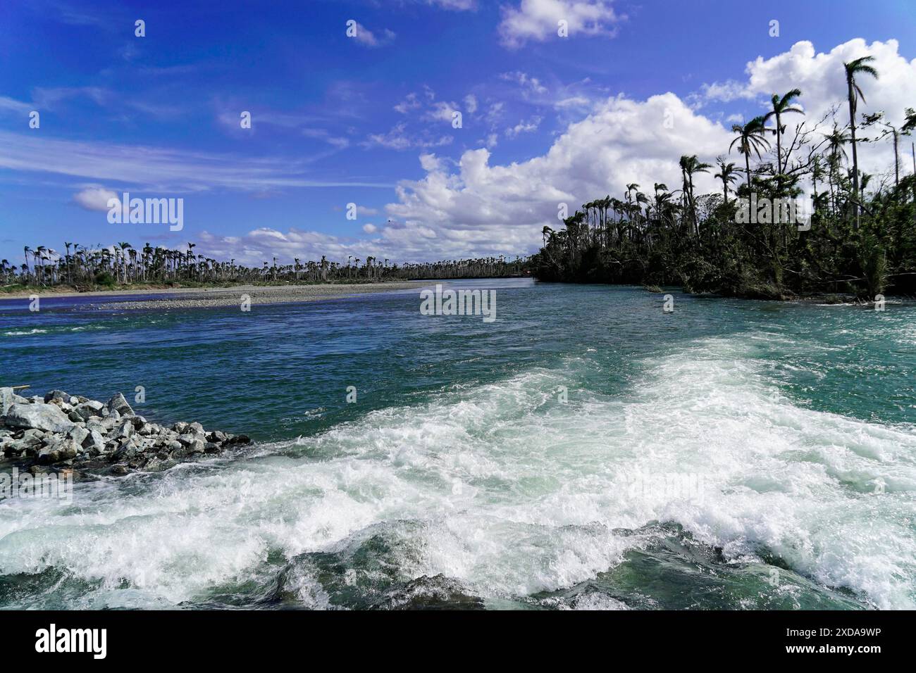 Cuba, Cuba, America centrale, Un fiume con onde forti, circondato da vegetazione tropicale sotto un cielo parzialmente nuvoloso Foto Stock