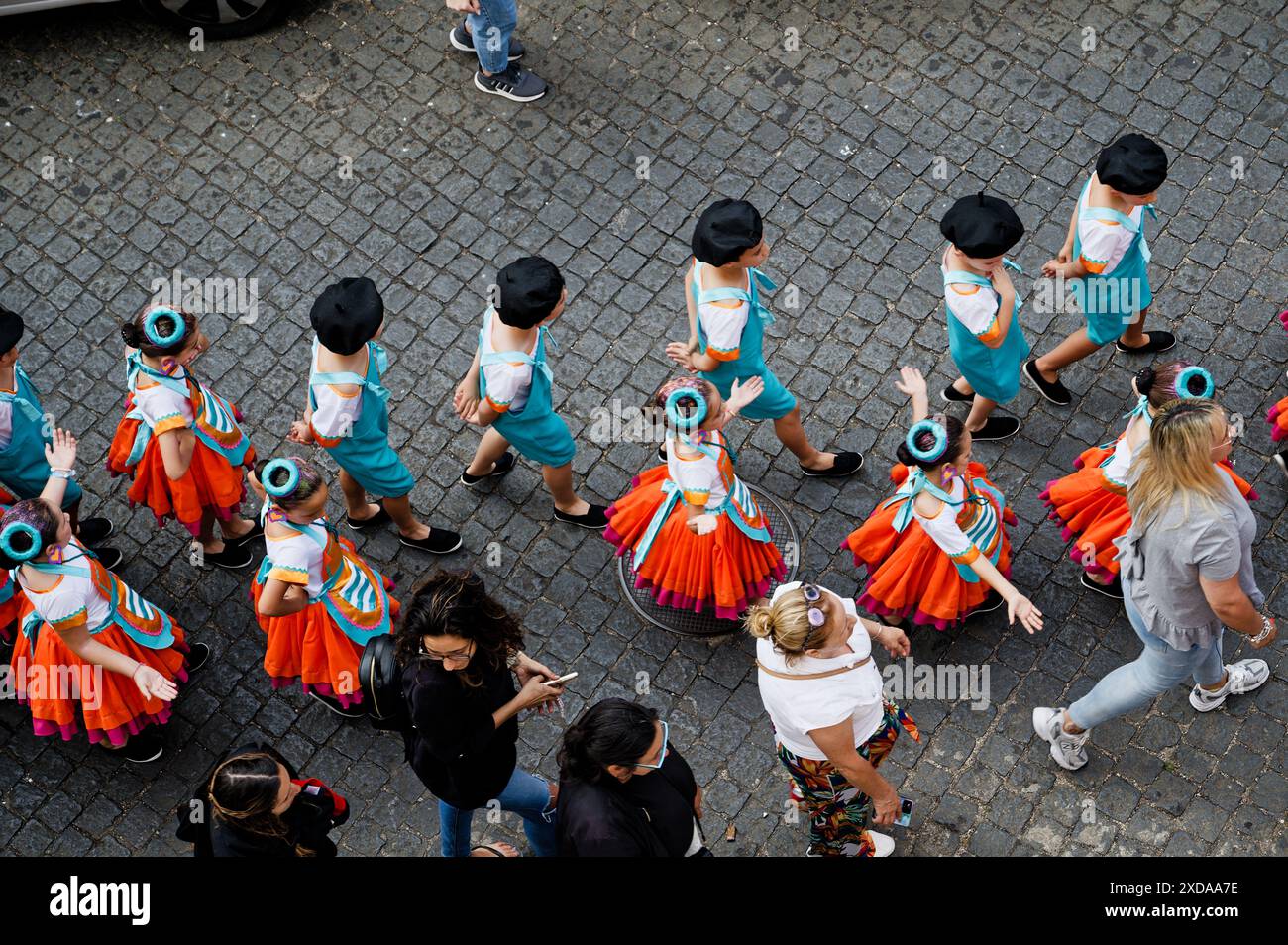 I bambini di una scuola locale sfilano in costumi colorati il giorno portoghese nelle strade acciottolate di São Vicente Foto Stock