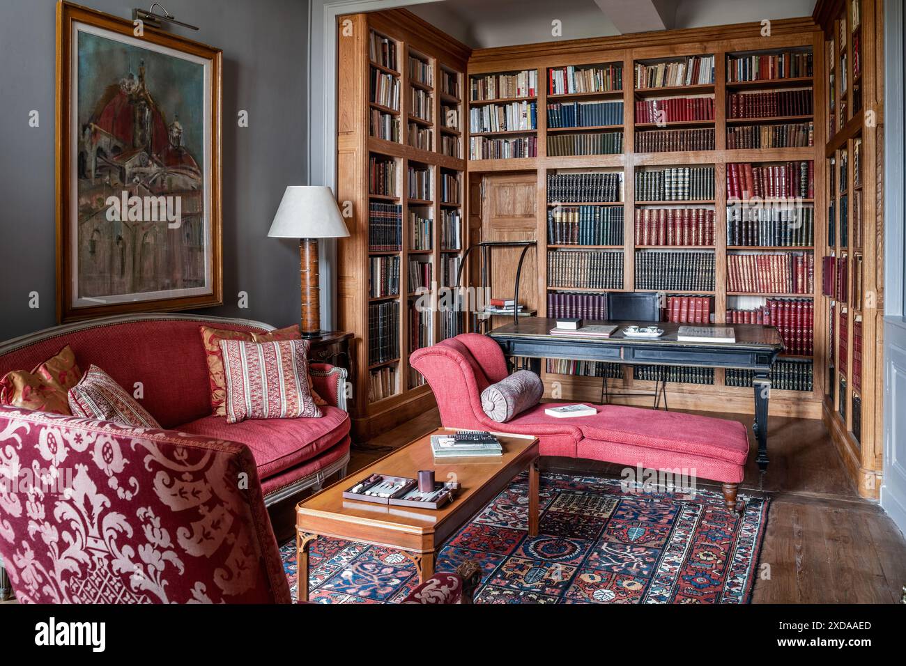 Chaise longue e divano con vecchia libreria in legno in un hotel ristrutturato in pietra risalente al 1770 a Saulieu, Borgogna, Francia. Foto Stock