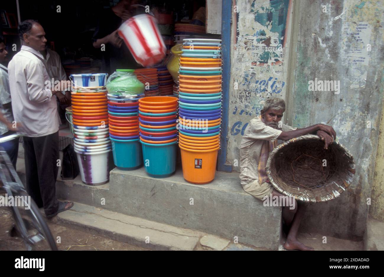 Un negozio di secchi platic e un vecchio con un secchio naturale in una strada di mercato nella città di Chennai, nella provincia di Tamil Nadu, in India. India, Chennai, AP Foto Stock