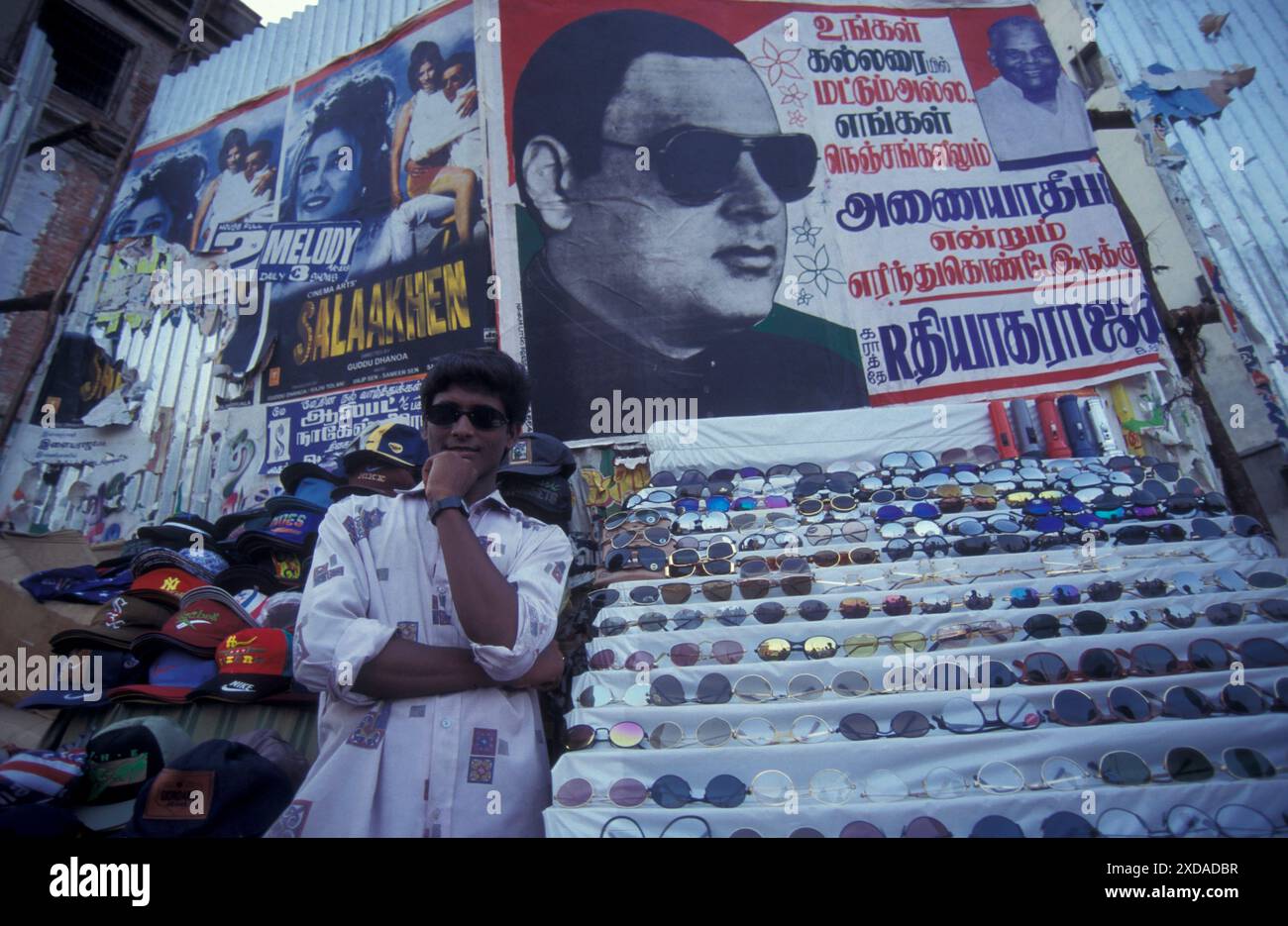 Un uomo in un negozio di lezioni di sole in una strada di mercato nella città di Chennai, nella provincia di Tamil Nadu, in India. India, Chennai, aprile 1998 Foto Stock