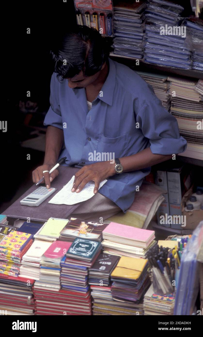 Un uomo in un negozio in una strada commerciale nella città di Chennai, nella provincia Tamil Nadu, in India. India, Chennai, aprile 1998 Foto Stock