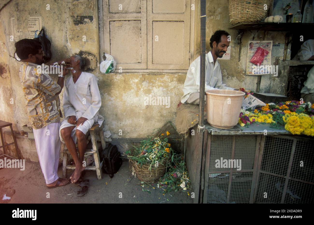 Un uomo in un barbiere in una strada commerciale nella città di Chennai, nella provincia di Tamil Nadu, in India. India, Chennai, aprile 1998 Foto Stock