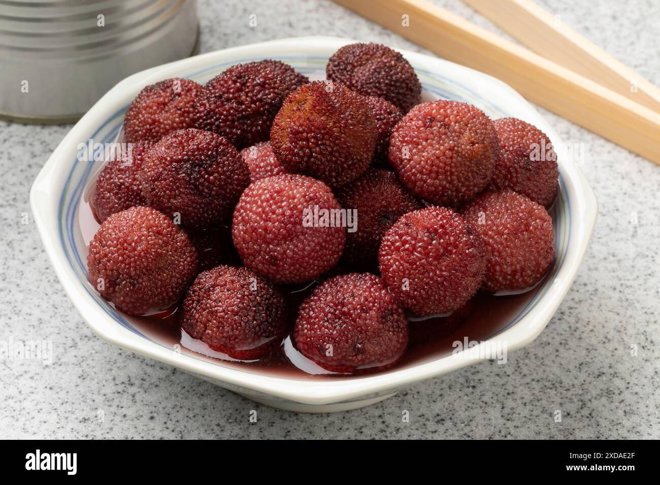 Ciotola bianca con bacche di Arbutus in sciroppo da vicino Foto Stock