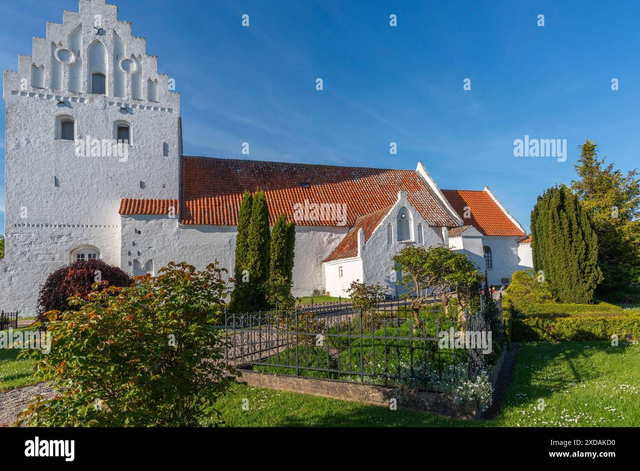 Chiesa imbiancata a Dalby, vista laterale, cimitero, timpano a gradini, Fyn, North Funen, Danimarca Foto Stock