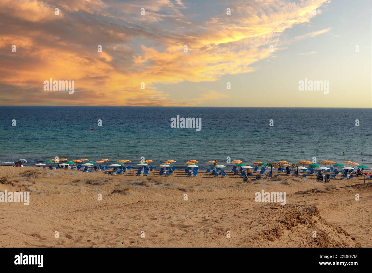 Spiaggia di Corfù al tramonto con ombrelloni Foto Stock