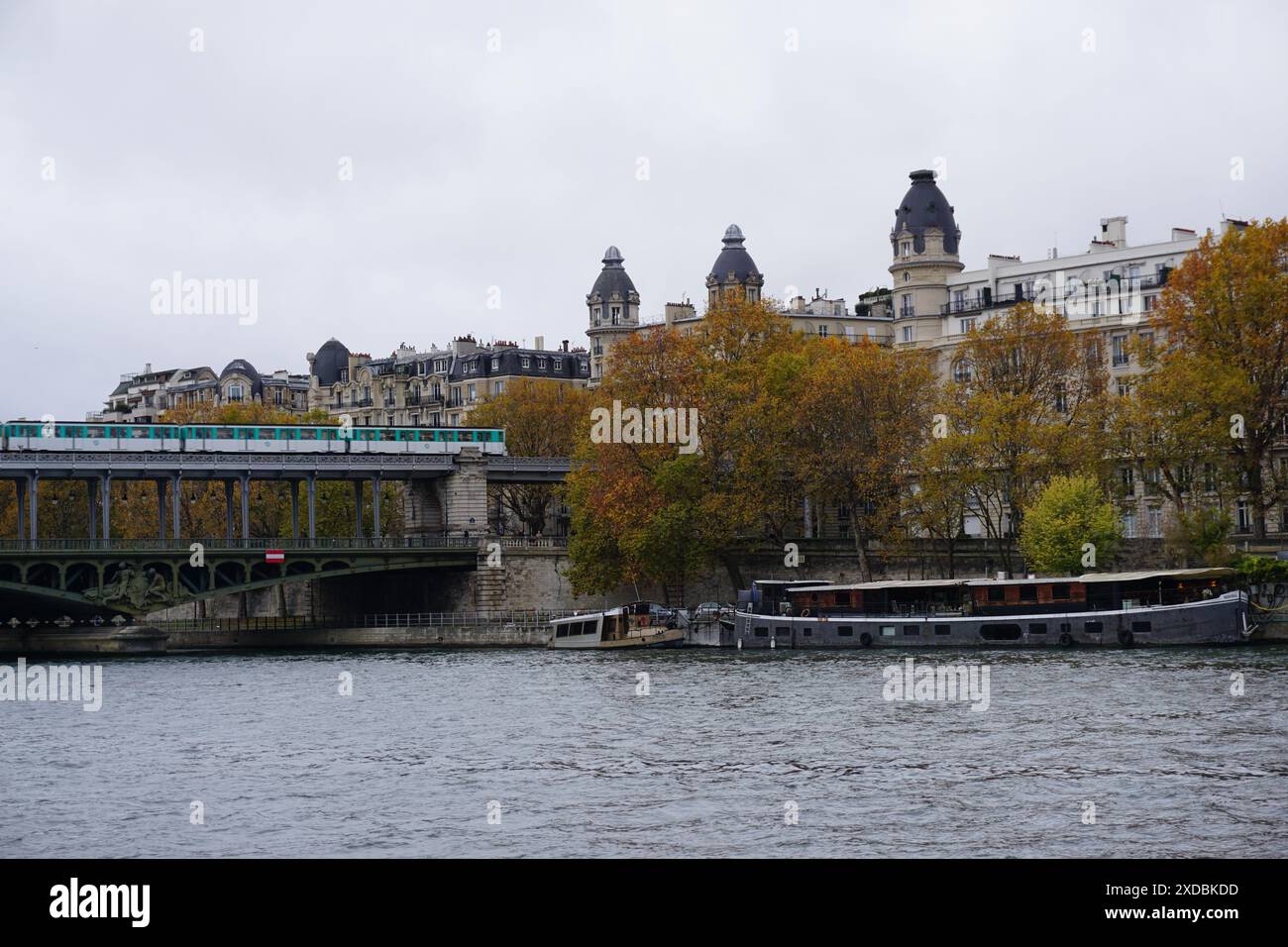il fiume senna con chiatte nel centro di parigi in francia con il ponte bir hakeim e la metropolitana Foto Stock