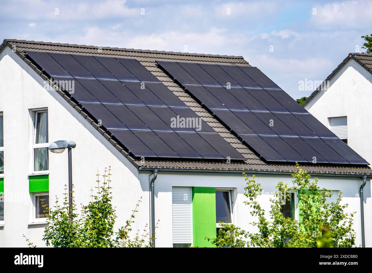 Tetto solare, pannelli solari su un tetto a falda di un edificio residenziale, generazione di energia rinnovabile, Foto Stock