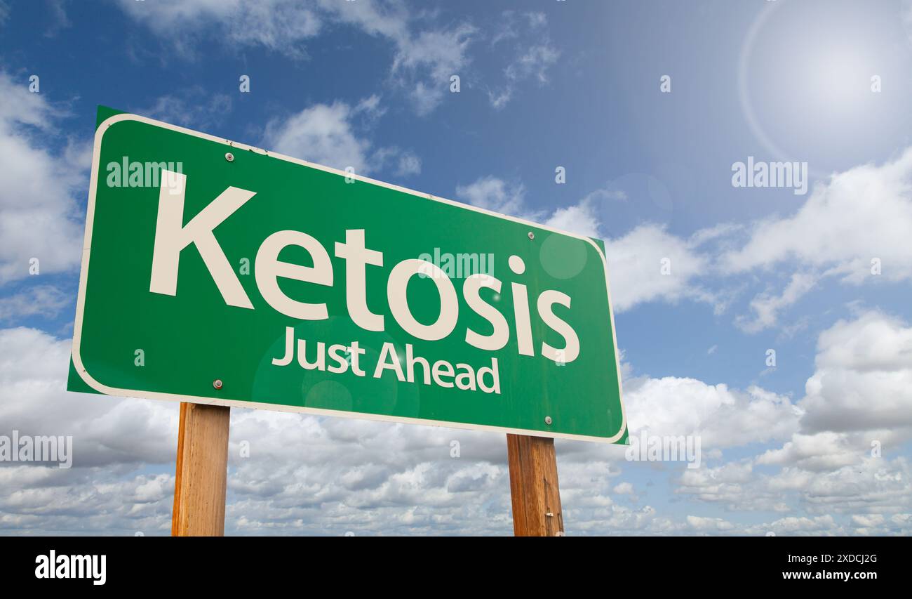 Ketosis poco più avanti, cartello con la Green Road su Clouds e Blue Sky. Foto Stock