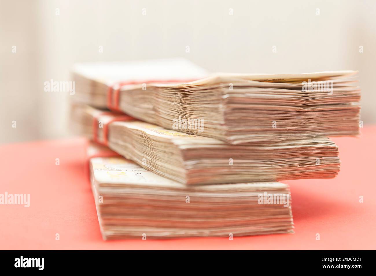 Una pila di soldi è accumulata l'una sull'altra. Il denaro è di denominazioni diverse ed è legato insieme a stringhe rosse. Concetto di ricchezza e abu Foto Stock