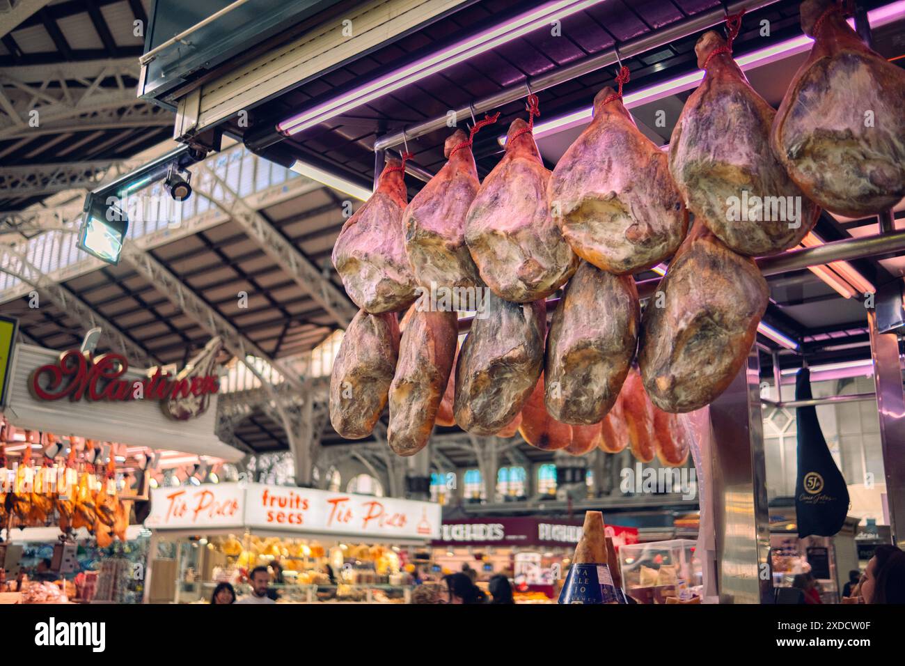 Valencia, Spagna 1.03.2024: Vendita di jamon sul mercato. Il prosciutto sotto forma di mozziconi di maiale è appeso al bancone, in attesa dei clienti. Prodotto nazionale di SP Foto Stock