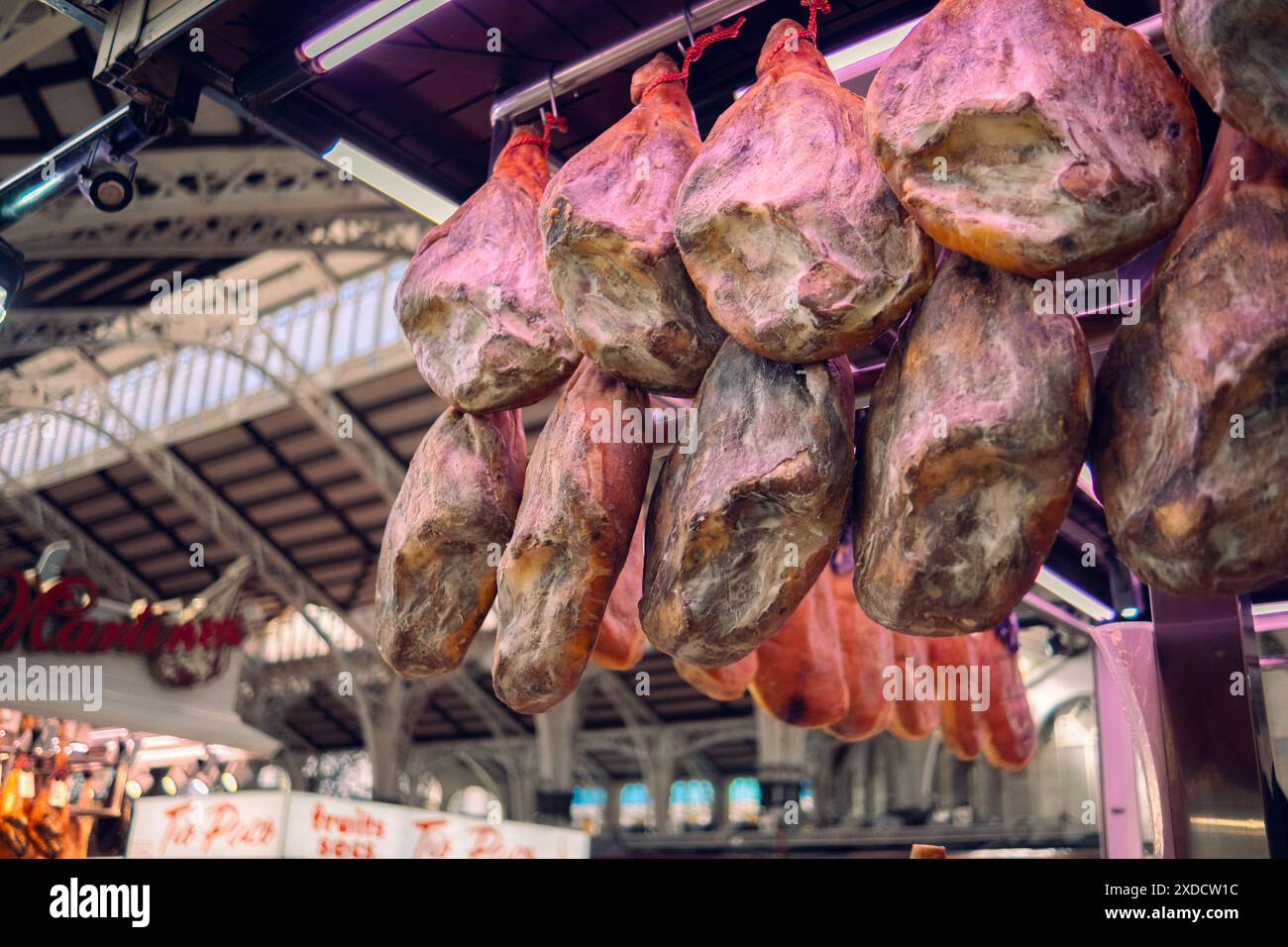 Valencia, Spagna 1.03.2024: Vendita di jamon sul mercato. Il prosciutto sotto forma di mozziconi di maiale è appeso al bancone, in attesa dei clienti. Prodotto nazionale di SP Foto Stock