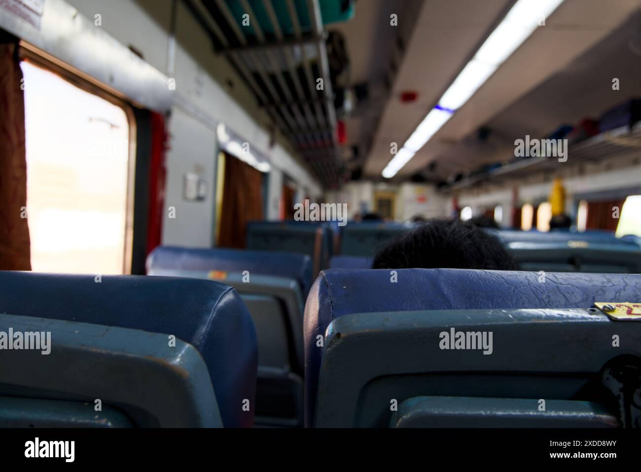 All'interno di un treno indiano, i passeggeri occupano posti blu durante il loro viaggio giornaliero. Una fetta di vita dalle ferrovie indiane. Foto Stock