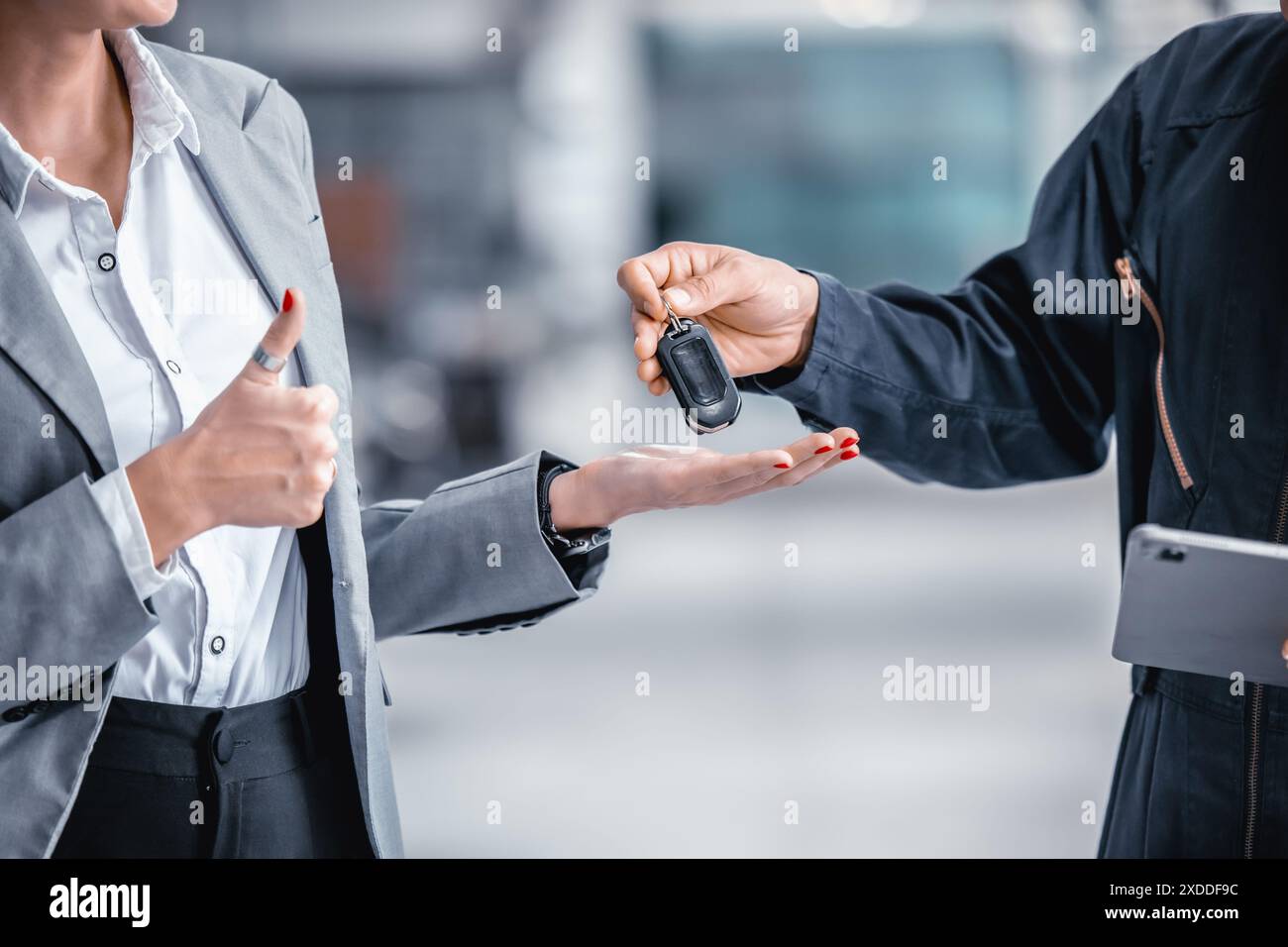 Closeup mano maschio che dà una chiave di automobile per il credito di prestito di veicolo finanziario, leasing o concetto di noleggio Foto Stock