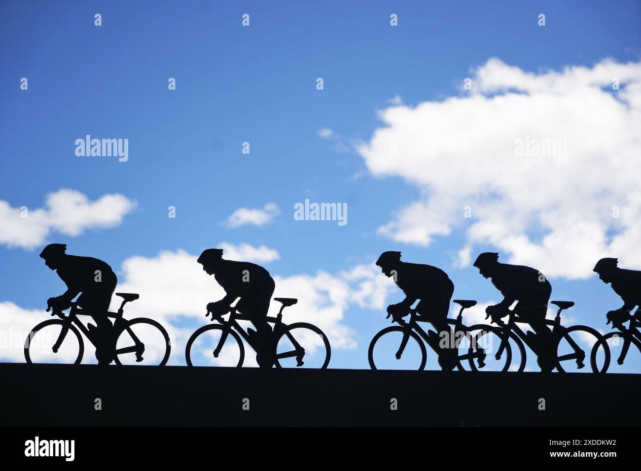 Lanslebourg-Mont-Cenis , Francia - 20 giugno 2024: Un gruppo di ciclisti affronta la ripida salita alpina sotto la luce posteriore. Foto Stock