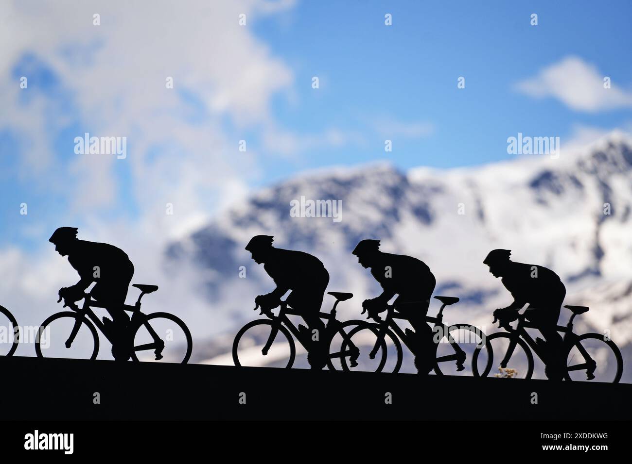 Lanslebourg-Mont-Cenis , Francia - 20 giugno 2024: Un gruppo di ciclisti affronta la ripida salita alpina sotto la luce posteriore. Foto Stock