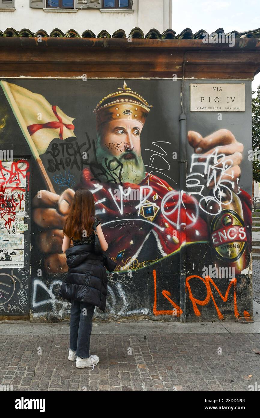 Vista posteriore di una ragazzina (13 anni) che guarda il murale "Milan Street Hi-Story" in via Pio IV, accanto alle colonne di San Lorenzo, Milano, Lombardia Foto Stock
