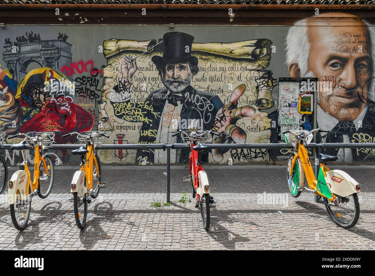 Stazione di bike sharing di fronte al murale "Milan Street Hi-Story" in via Pio IV, accanto alle colonne di San Lorenzo, Milano, Lombardia, Italia Foto Stock