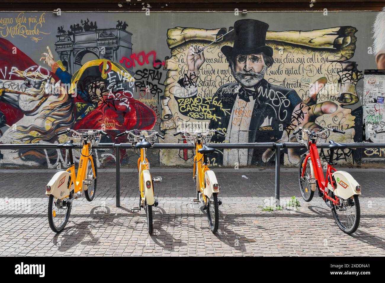 Stazione di bike sharing di fronte al murale "Milan Street Hi-Story" in via Pio IV, accanto alle colonne di San Lorenzo, Milano, Lombardia, Italia Foto Stock